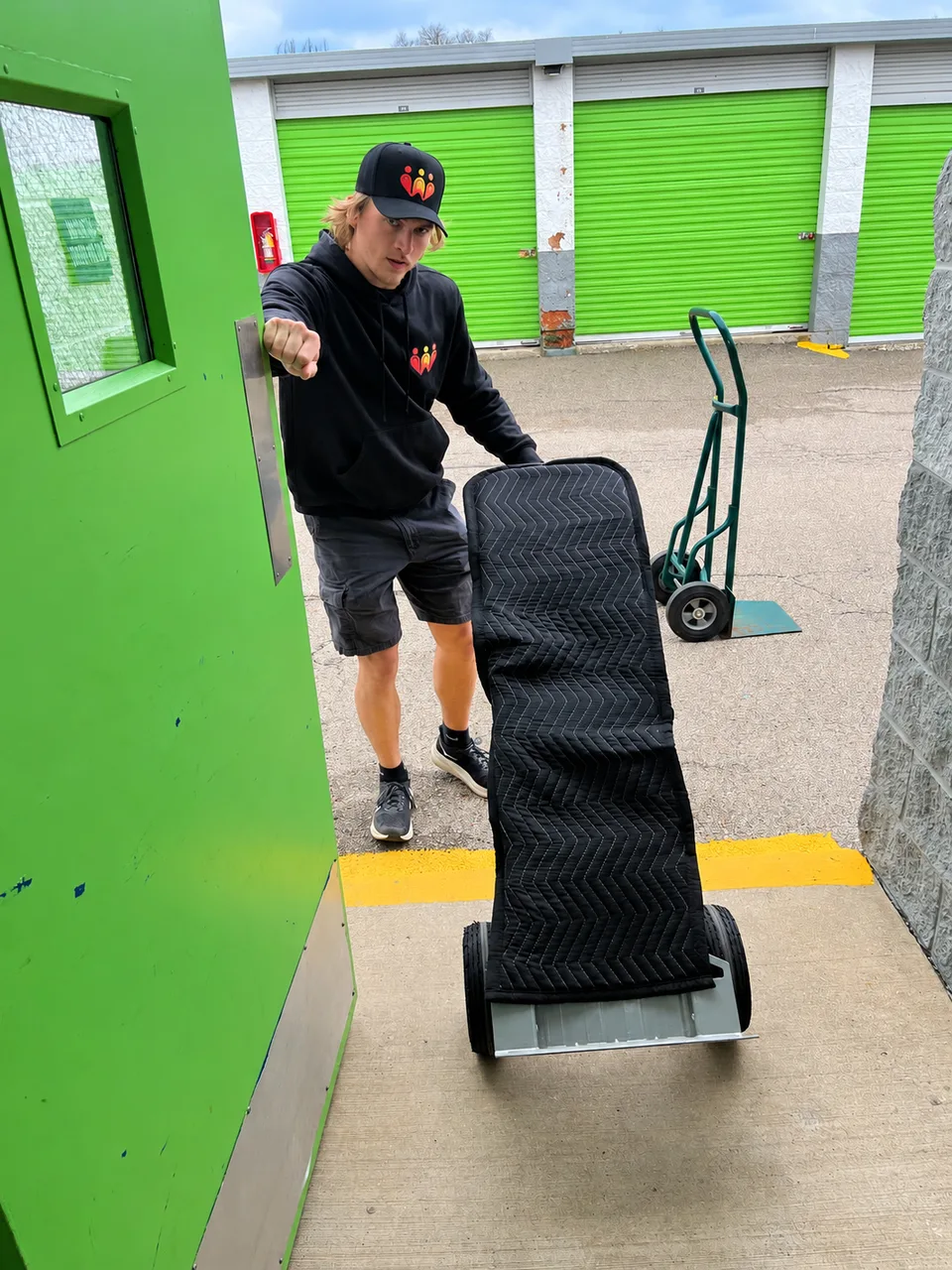 Austin, co-owner of Second Chance, handling a blanket-protected item at a storage facility